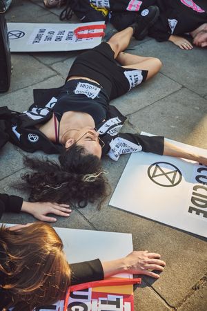 London, England, United Kingdom - September 15th,2019: Female protestor lying on street among signs