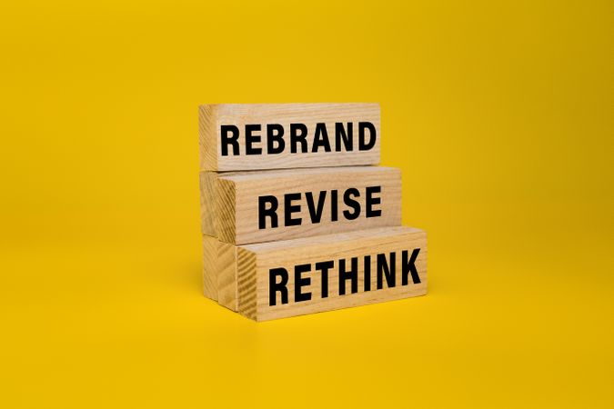 rethink revise and rebrand words on wooden blocks isolated on yellow background
