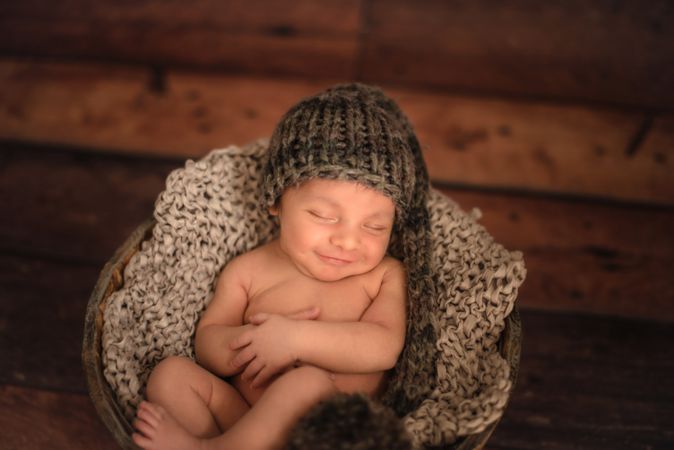 Naked baby sleeping in bucket
