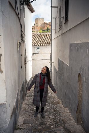 Joyful female tourist in casual wear amid city street