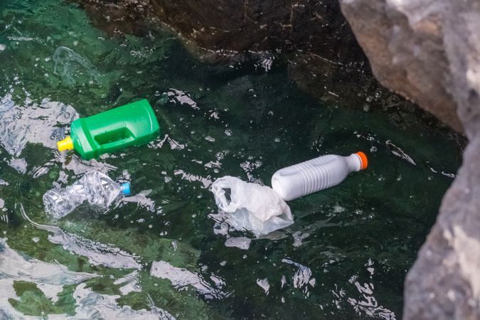 Plastic bottles and bag floating on water