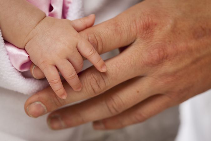 Baby Girl Hand Holding Rough Finger of Dad