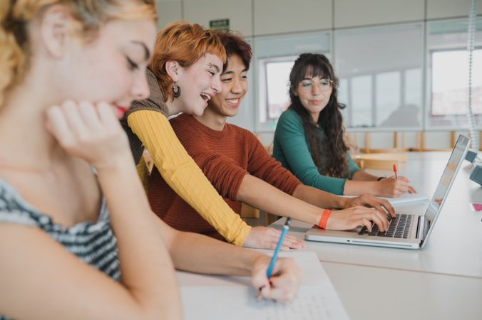 Diverse students studying together using netbook in university