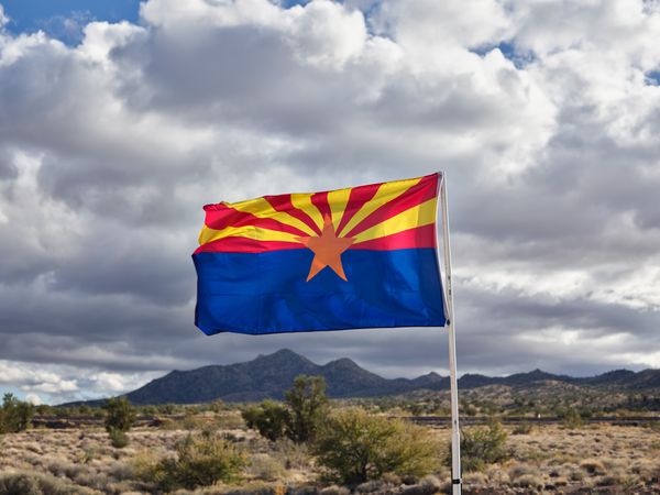 Arizona state flag billowing against cloudy desert sky