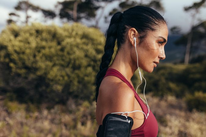 Side view of fitness woman standing outdoors ready for morning run