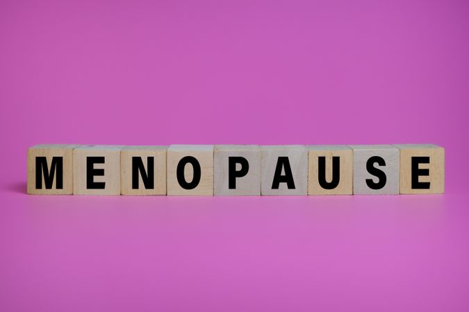 menopause words text on wooden blocks isolated on pink background