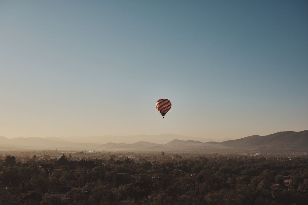 Hot air balloon in flight over pyramids in Teotihuacan Valley