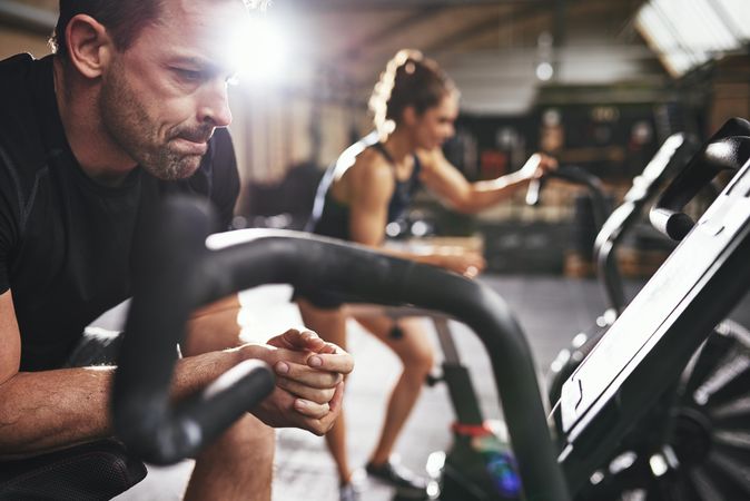 Tired male checking personal performance stats on cycling bike
