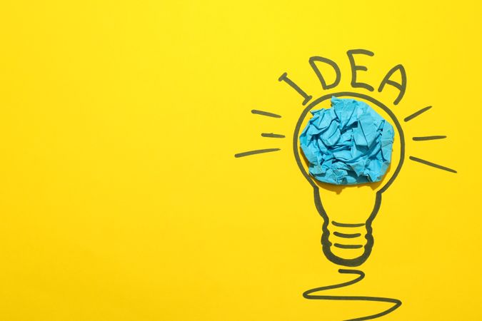 Drawn light bulb and paper ball on yellow background. Good idea concept