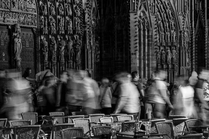 People walking in front of busy French cathedral