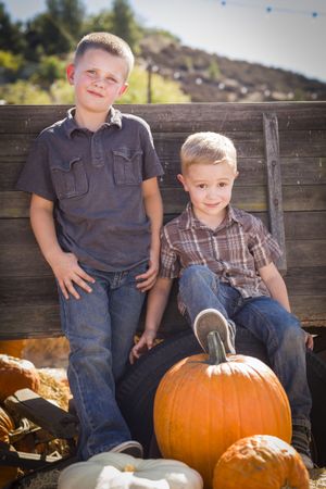 Boys Having Fun at the Pumpkin Patch on a Fall Day.