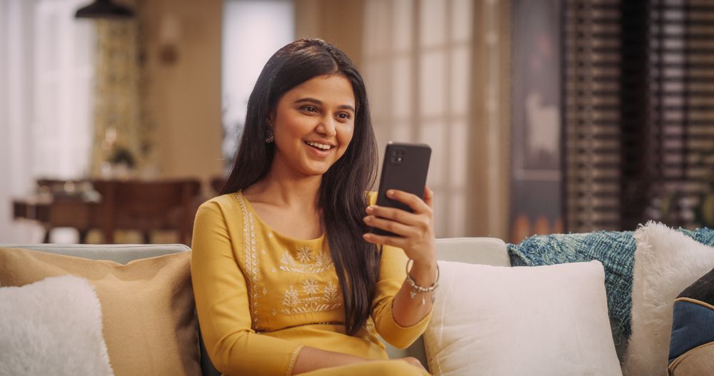 Indian Woman Using Video Call On Smartphone At Home: Doing Remote Work, Making Video Meetings with Clients.