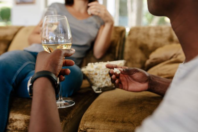 Couple at home drinking wine and eating popcorn