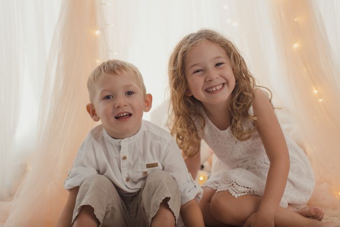 Sister embracing little brother at home