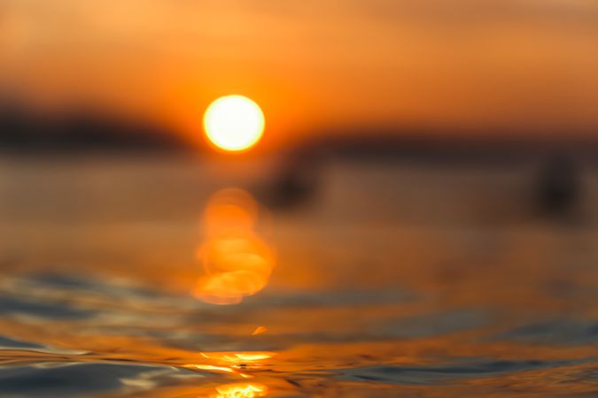 Water surface and sky with sun at sunset