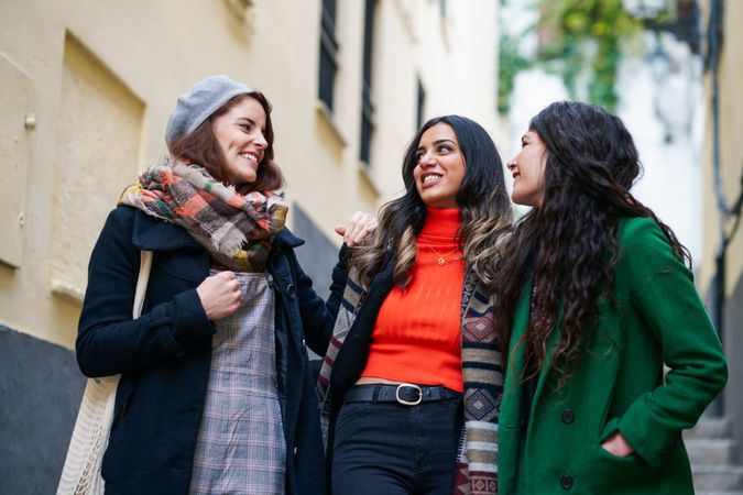 Three women dressed in fall clothes together on a walk