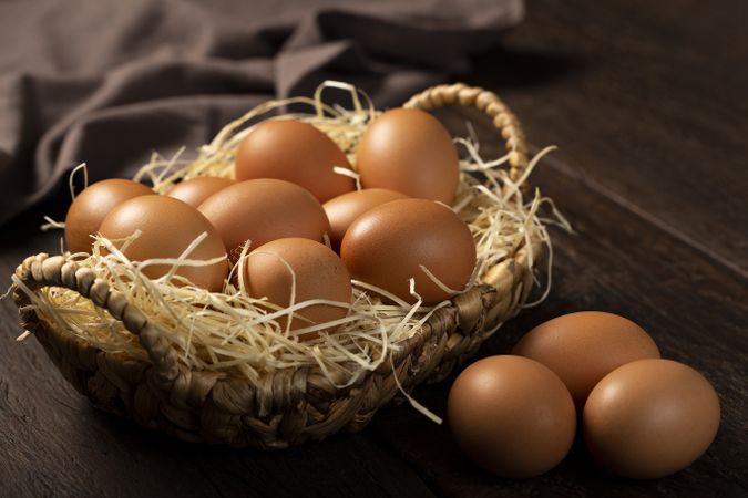 Basket with brown chicken eggs goes up the table.