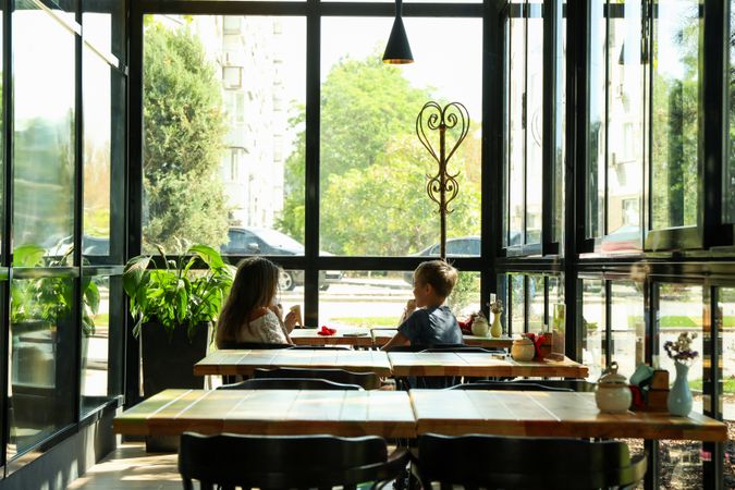 Two children eat ice cream in restaurant