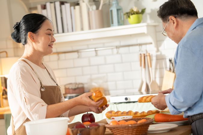 Asian older couple cooking breakfast in the kitchen