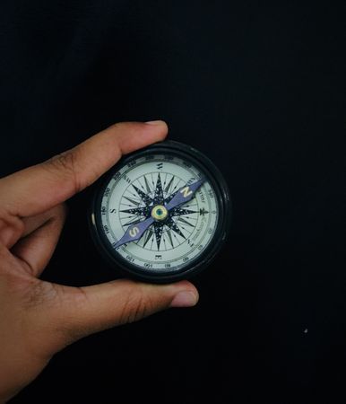 Person holding compass pointing toward north east
