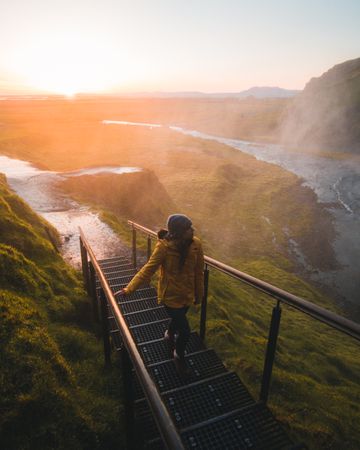 Woman climbing on stairs facing mountains