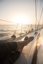 Man lying on edge of yacht on water