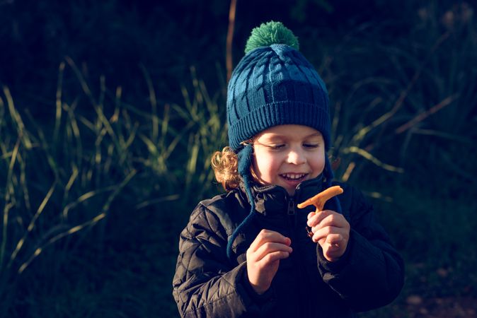 Positive boy with mushroom in nature