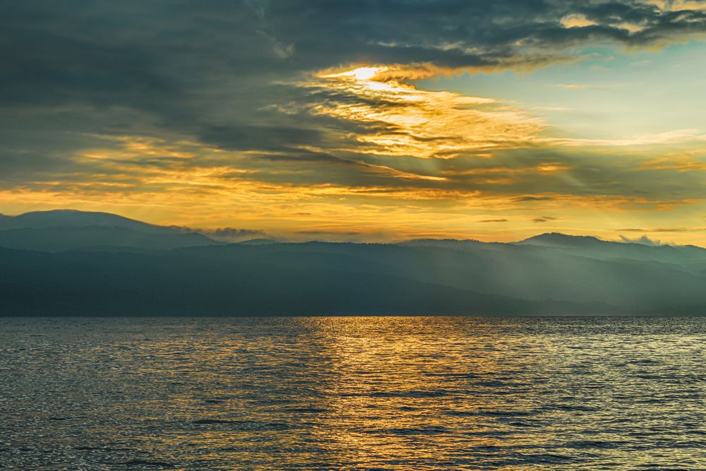 beautiful lake view at sunrise with mountain and dramatic clouds