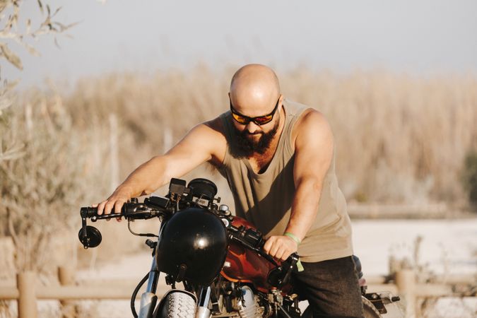 Serious male driving motorcycle in forest