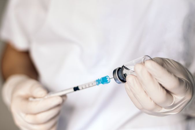 Nurse injecting vaccine into a syringe. Vaccination concept. Coronavirus