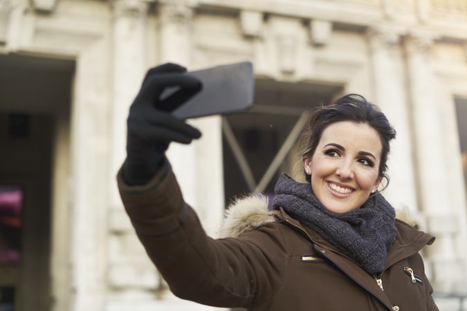 Young woman taking a selfie with smart phone outdoors