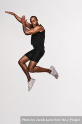 Portrait of Black athlete jumping in air bDnnQ5