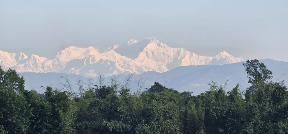 Snowy Mountain Range Over Lush Forest