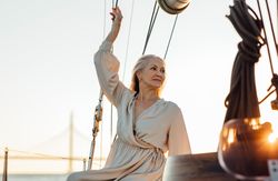 Beautiful mature woman sitting on a yacht bow