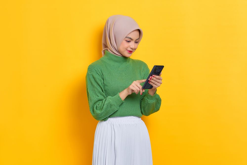 Woman in headscarf reading her smart phone
