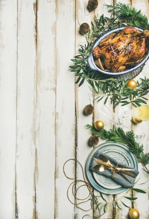 Roast chicken, table setting, decorations of festive fir, on a light background, copy space