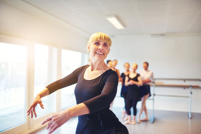 Happy woman in ballet pose during class