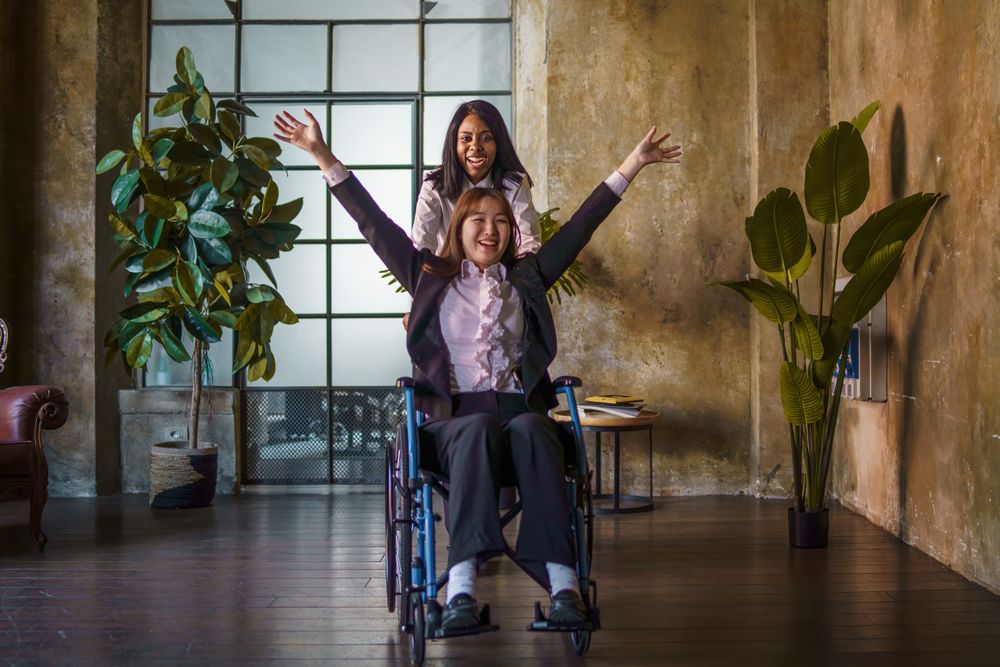 Woman happily pushing other woman in a wheelchair
