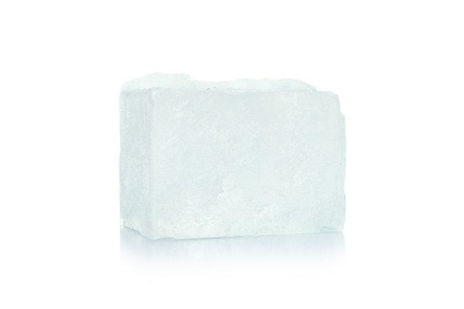 Single ice cube on bright background