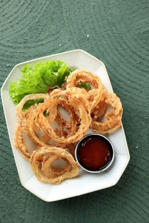 Deep Fried Onion Rings on Ceramic Plate, Served with Spicy Sauce.