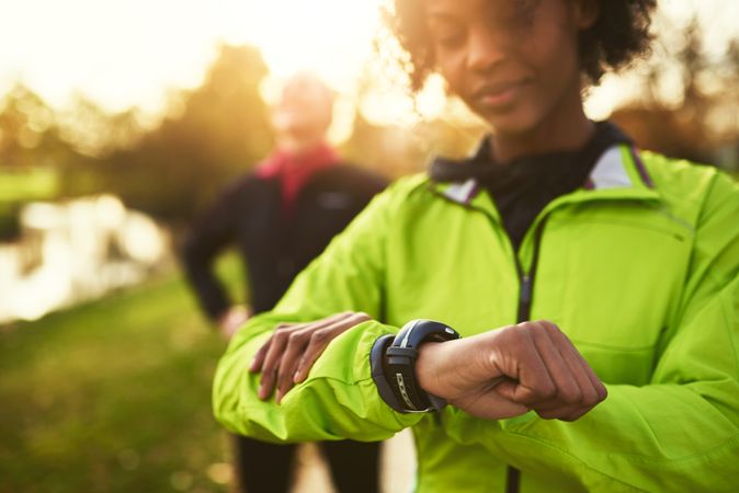 Woman checking smartwatch in a sunny park