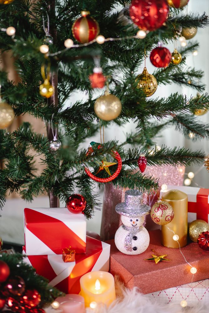 Gift boxes and string light under Christmas tree indoor