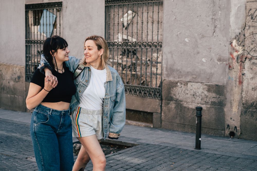Lesbian couple hugging and walking on street