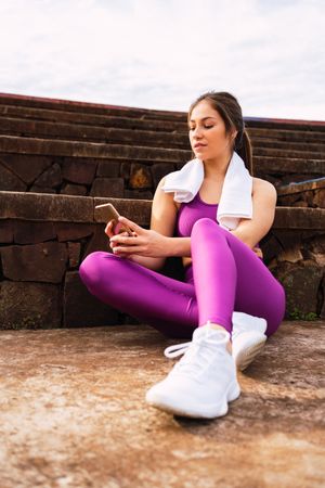 Slim woman in sportswear by stone stairs