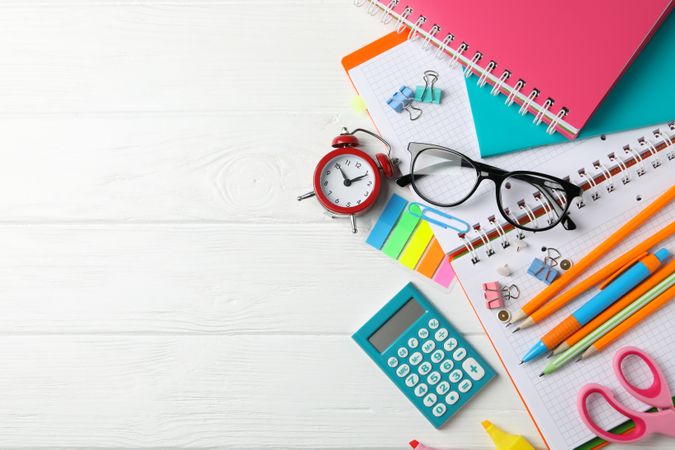 Stationary and school accessories scattered on plain background with copy space