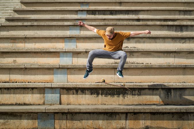 A young man doing an ollie flip with his skateboard on some bleachers