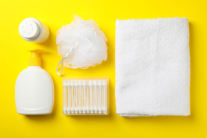 Flat lay with baby hygiene accessories on yellow background