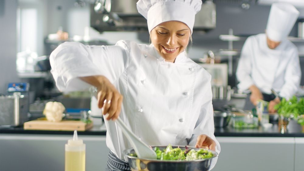 In a Famous Restaurant Female Cook Prepares Salad. She Works in a Big Modern Kitchen.