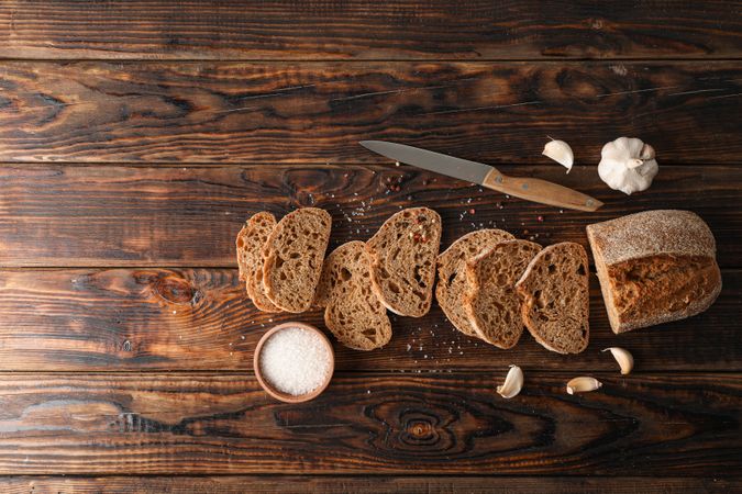Flat lay composition with freshly baked bread on wooden background, top view and space for text