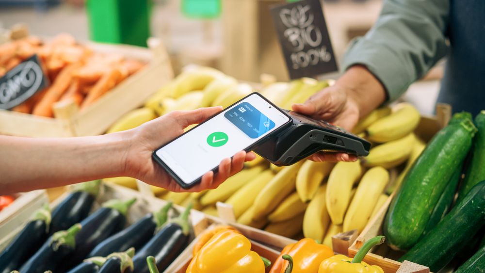 Street Vendor Holding an Electronic Payment and a Card Reader Device